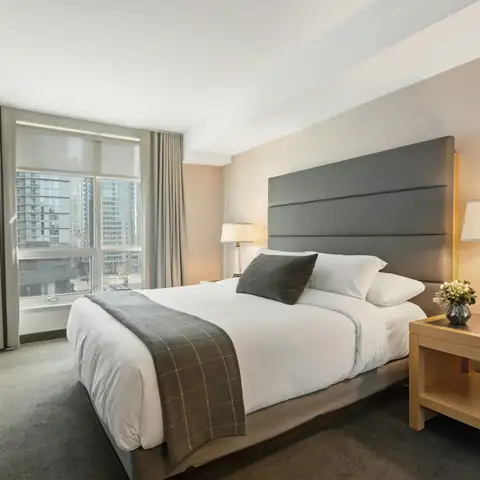 A bed with a grey headboard in a bedroom